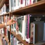 person-holding-book-from-shelf-1370298